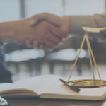 Two individuals shaking hands over a legal book, with a scale of justice in the foreground, symbolizing partnership and legal services in Michigan. This image represents the importance of professional relationships in Michigan web design for law firms.