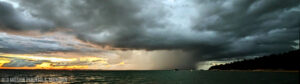 Stormy skies over a lake, showcasing dark clouds and rain in the distance, highlighting the natural beauty of Michigan's waterfront. Ideal for Michigan web design inspiration.