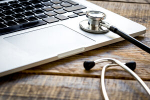 Close-up of a laptop keyboard with a stethoscope, symbolizing the intersection of technology and healthcare, relevant for Michigan web design focused on medical professionals and services.