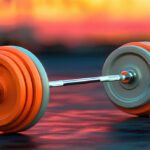 Close-up of a barbell with orange weights on a gym floor, representing fitness and strength training. Ideal for Michigan web design related to health and wellness websites.