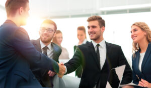 Business professionals shaking hands in a modern office setting, representing collaboration and networking in Michigan web design.